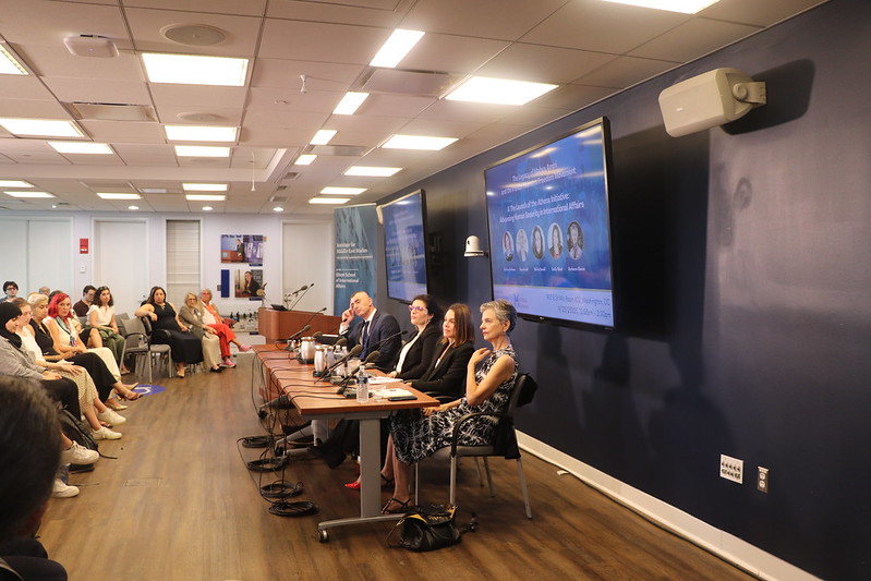 Members of the Athena Initiative sitting in front of audience at table with microphones